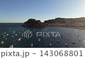 An aerial view of a drone flying over a bay with moored boats and yachts at sunset in the tourist town of Tossa De Mar, Catalonia, Spain 143068801