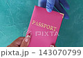 Airport check-in. Travel safety. Immigration officer hand in protective glove taking female passenger passport in pink cover on blue set of 4 loop. 143070799