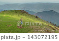 Lone Hiker on Sunlit Grassy Ridge in the Pyrenees 143072195