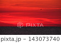 Sunset over the ocean with vibrant red sky 143073740