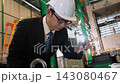 The engineer is inspecting the work in the factory. 143080467