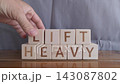 motivational word Lift heavy, laying out by hand from letters on wooden cubes, slow motion 143087802