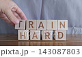 motivational word Train hard, laying out by hand from letters on wooden cubes, slow motion 143087803