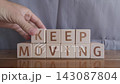 motivational word Keep moving, laying out by hand from letters on wooden cubes, slow motion 143087804