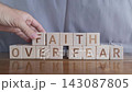 motivational word Faith over fear, laying out by hand from letters on wooden cubes, slow motion 143087805