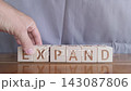 motivational word Expand, laying out by hand from letters on wooden cubes, slow motion 143087806