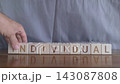 motivational word Individual, laying out by hand from letters on wooden cubes, slow motion 143087808