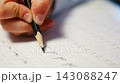 First grade student practices writing letters with pencil in workbook. Early literacy and handwriting skills develop with selective focus and shallow depth of field 143088247