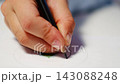 First grade student practices writing letters with pencil in workbook. Early literacy and handwriting skills develop with selective focus and shallow depth of field 143088248
