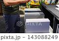 Man browses cabinet door samples in furniture showroom. Choosing colors and finishes for kitchen renovation with selective focus and soft background 143088249