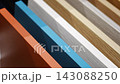 Woman touches countertop samples while choosing material in furniture showroom. Home renovation and interior design choice captured with selective focus and shallow depth of field 143088250