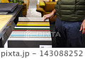Man browses cabinet door samples in furniture showroom. Choosing colors and finishes for kitchen renovation with selective focus and soft background 143088252