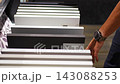 Man browses cabinet door samples in furniture showroom. Choosing colors and finishes for kitchen renovation with selective focus and soft background 143088253
