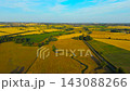 Countryside with golden crop fields, green farmland and grazing pasture under blue sky. Rural agricultural region for food production and farm economy. Fertile land for farming business, investment 143088266