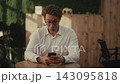 Portrait of upset man with glasses sitting in cafe, looking at smartphone with funny and confused expression, reacting to bad news, negative message received working. Shooting in slow motion. 143095818