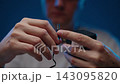 Close-up of person hands connecting coaxial power connector to black electrical adapter, concept of power supply, charging, electrical connectivity. Shooting in slow motion. 143095820