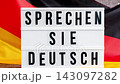 Lightbox with text SPRECHEN SIE DEUTSCH DO YOU SPEAK GERMAN National symbol of Germany. German wave silky flag background. education and learning languages 143097282