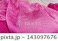 A vibrant red silk fabric falls in slow motion onto a soft cream and light pink textile background. This multi-colored drapery creates elegant layers ideal for luxury fashion and modern apparel design 143097676