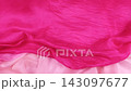 A pink silk fabric falls smoothly onto a magenta textile in slow motion. The elegant soft material creates gentle waves and contrasting colorful folds.  143097677