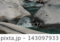 Slow-motion footage of alpine water sliding smoothly across angled rock surface 143097933