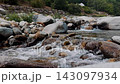 Ground level view of turbulent alpine water rushing through narrow rocky gorge 143097934