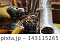 Close Up Of Metal Grinding Process With Bright Sparks Shower From Seam. Industrial Angled Grinder Machine Cleaning Welded Joint Area Inside Heavy Manufacturing Factory Workshop 4k 143115265