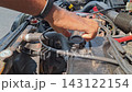 Close-up shot of hand unscrewing black oil cap, car engine, mechanic working, checking fluid levels, automotive maintenance. 143122154