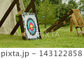 Caught mid flight, arrow drives into worn target among several earlier shots during rainy medieval event. authentic setting of traditional archery demonstration. 143122858