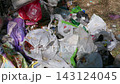 Discarded Plastic Waste Accumulating in Sunlight Outdoors in Park 143124045