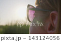 Young Woman in Sunglasses Enjoys Golden Sunlight Outdoors 143124056