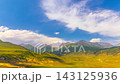 Timelapse of Kyrgyzstan mountain landscape with moving clouds and shifting shadows across green alpine hills 143125936