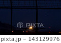 Airplane taking off at night with landing lights through airport fence 143129976
