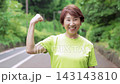 Senior woman in sportswear strikes a triumphant pose 143143810