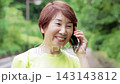Senior woman in sportswear talking on her smartphone 143143812