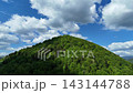Aerial Video Of Dense Green Forest Mountain Peak Under Blue Sky With Cumulus Clouds 143144788