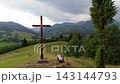 Side movement trucking shot of a wooden Christian cross on a mountain hill before storm 143144793
