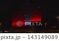 Aerial view of Latvian National Library in Riga at night during Riga Staro 2025, with red and white projection mapping, moving car, pedestrians, and lit avenue 143149089