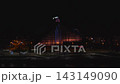 Aerial shot shows Latvian National Library in Riga lit in blue and red, Ferris wheel, riverside road, and Daugava reflections, low exposure and high contrast capture motion 143149090