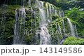 Beautiful tropical waterfall flowing through lush green forest, creating a peaceful natural landscape. High quality 4k footage 143149586