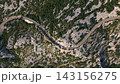 Aerial view of winding road through rocky mountains 143156275