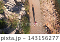 Woman running on rocky trail during outdoor workout from above 143156277
