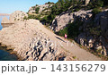 Woman Trail Running Along Rocky Coast 143156279