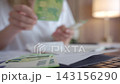 Woman counting money and paying bills with receipts 143156290