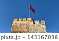 Turkish flag waving above historic stone fortress by the sea 143167038