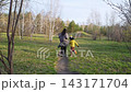 A mother is playing tag with her children in an autumn park. Two children running uphill. Outdoor game playing. Time with family, love, happy motherhood 143171704