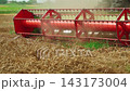 Combine harvester reel spinning while cutting ripe wheat in a field during harvest season, showcasing modern farming machinery 143173004