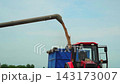 Combine harvester unloading ripe wheat grain into a tractor trailer during harvest season in slow motion 143173007