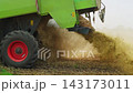 Combine harvester straw chopper spreading shredded wheat chaff and straw over a stubble field during the autumn harvest season 143173011