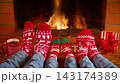 The family is sitting in front of the fireplace. People in clothes with Christmas ornaments are having fun at home. Slow motion 143174389