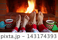 The family is sitting in front of the fireplace. Mother and child in clothes with Christmas ornaments are having fun at home. Slow motion 143174393